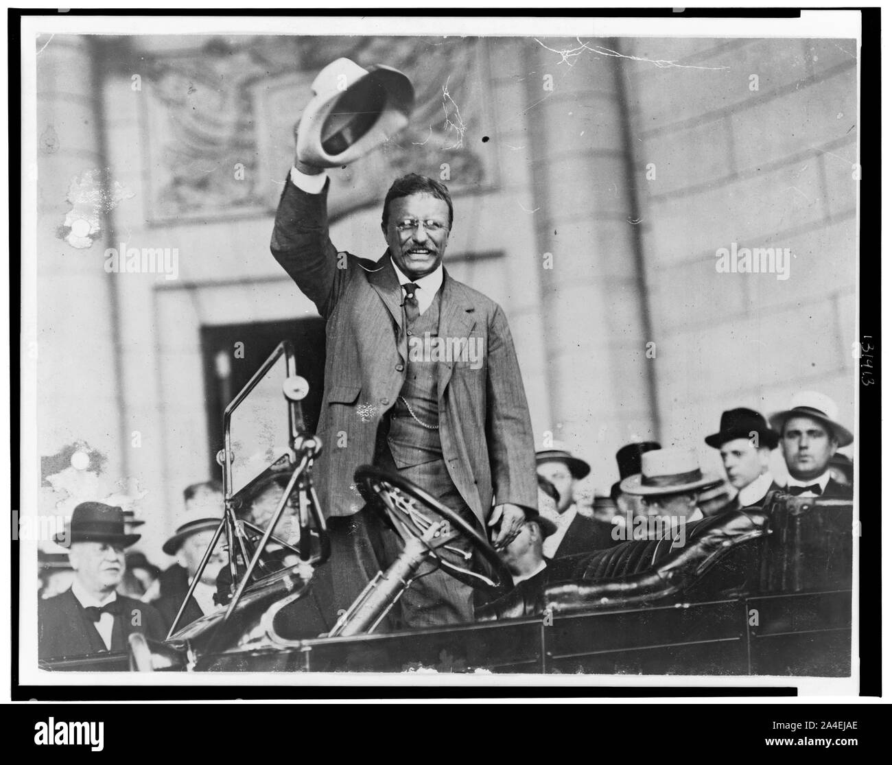 Theodore Roosevelt, three-quarter length portrait, standing up in car, waving hat Stock Photo