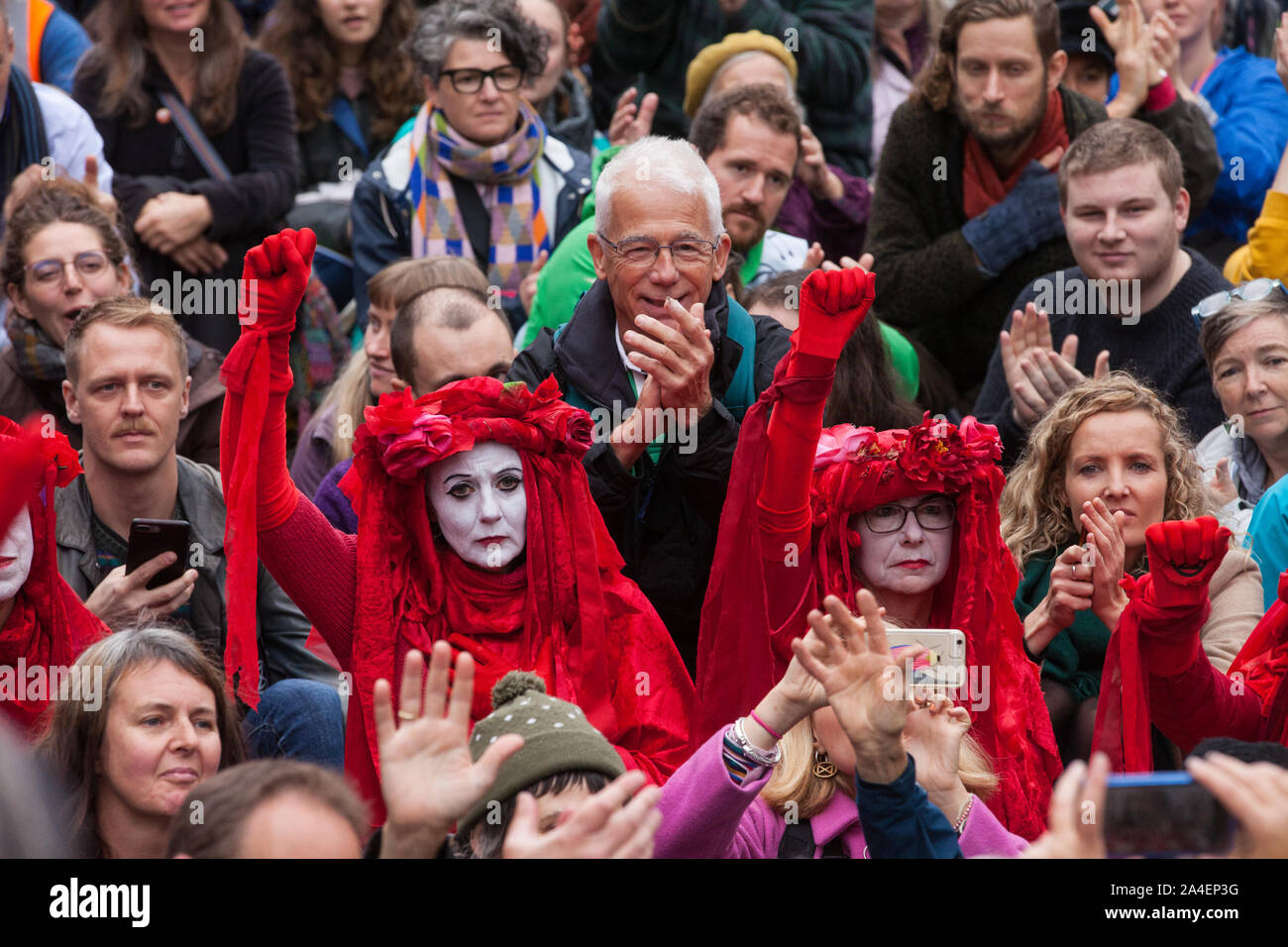 London, UK. 14 October, 2019. The Red Brigade joins fellow climate activists from Extinction Rebellion watching theatrical mock trials, of the UK’s financial sector for the crime of ecocide and of the Government for ‘criminal negligence’ in having permitted it, in front of the Bank of England. Roads were blocked around Bank on the eighth day of International Rebellion protests across London. Credit: Mark Kerrison/Alamy Live News Stock Photo