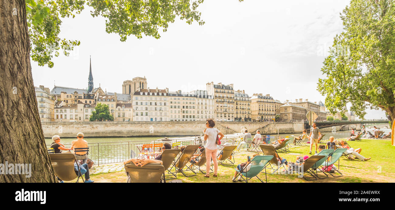 paris plages, people relaxing in deckchairs on the banks of river seine Stock Photo