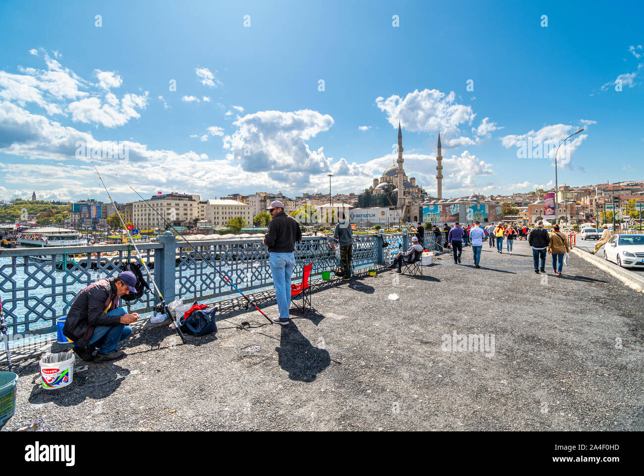 Local Turkish fishermen hang their fishing poles off the Bosphorus Bridge, with the Sultanahmet district and Suleymaniye Mosque in the distance. Stock Photo