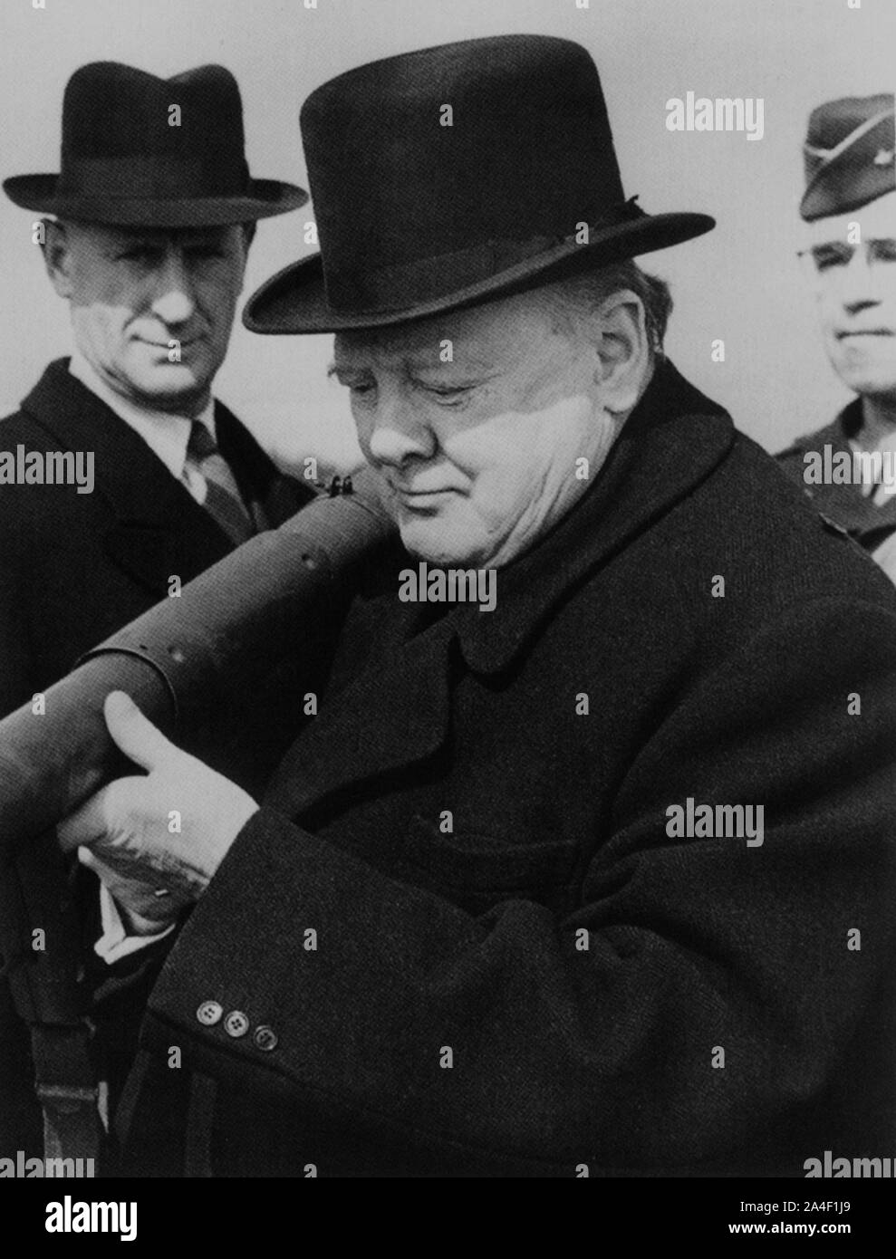 Churchill inspecting a bazooka anti-tank weapon. Churchill's protection officer, Inspector Thompson and General Omar Bradley look on. March 1944. Stock Photo