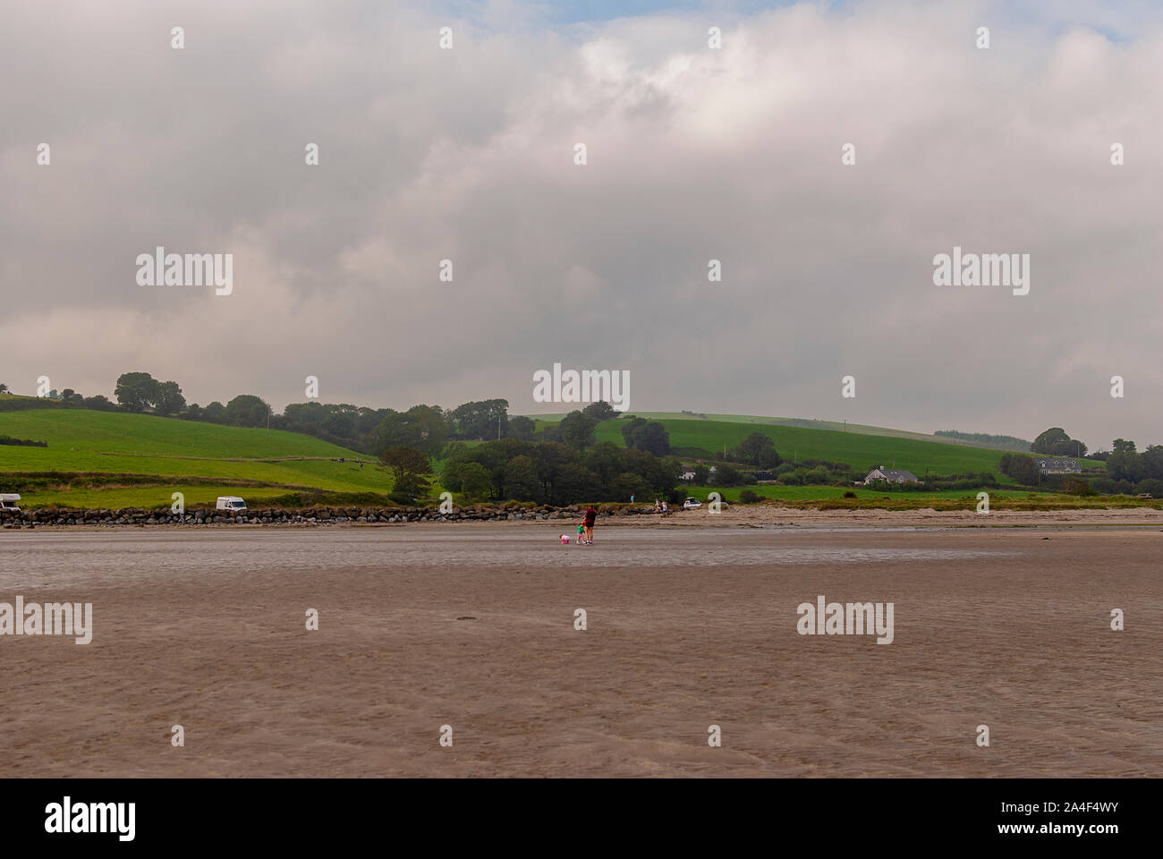 Couple walking on sandy beach leaving footprints in the sand. One ...