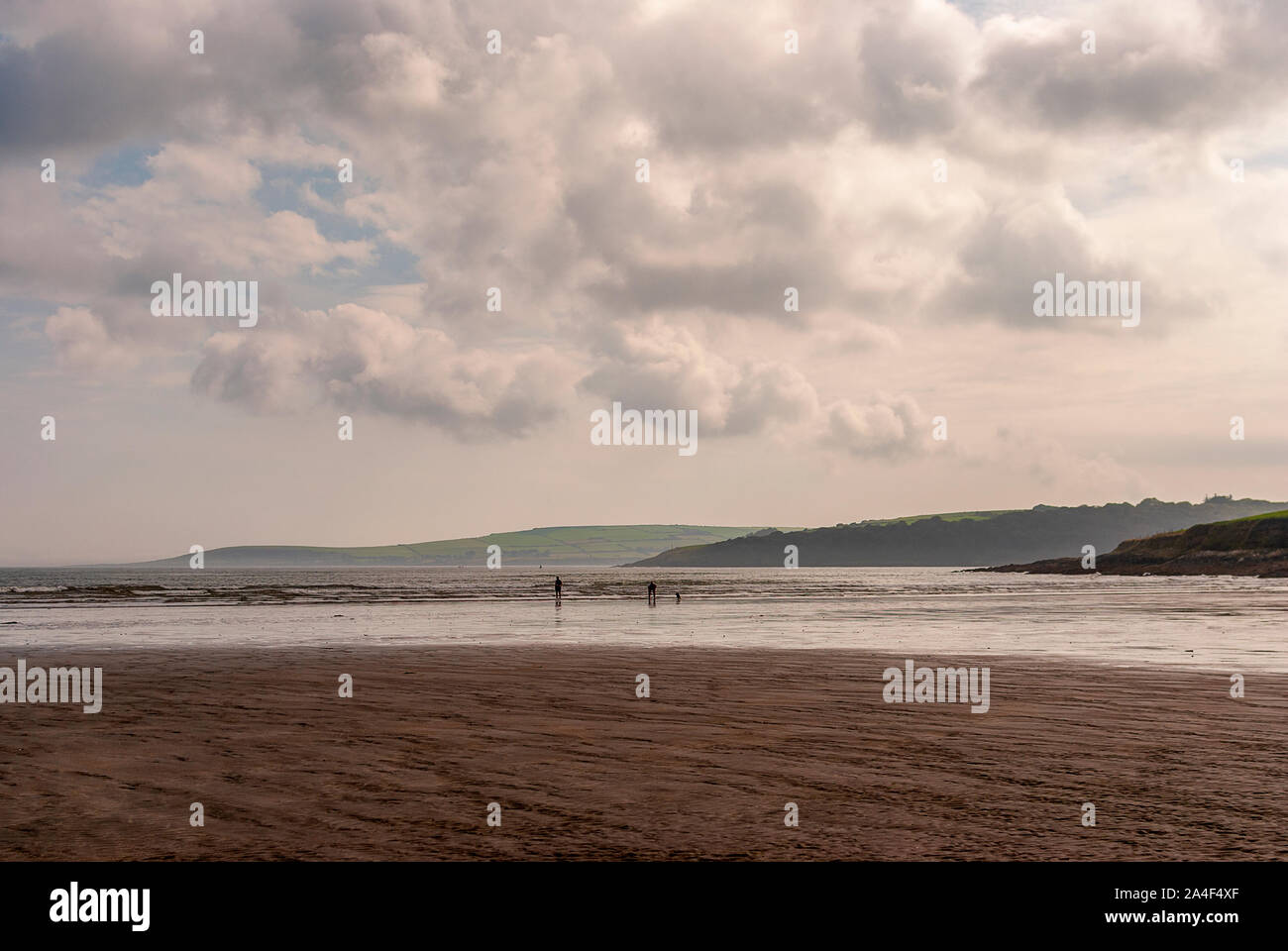 Couple walking on sandy beach leaving footprints in the sand. One ...