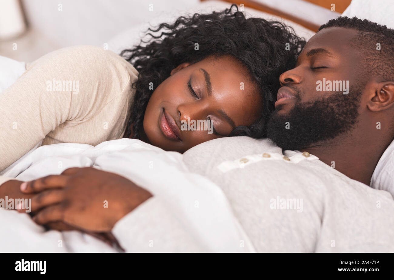 Portrait of black family couple sleeping together in bed Stock Photo ...