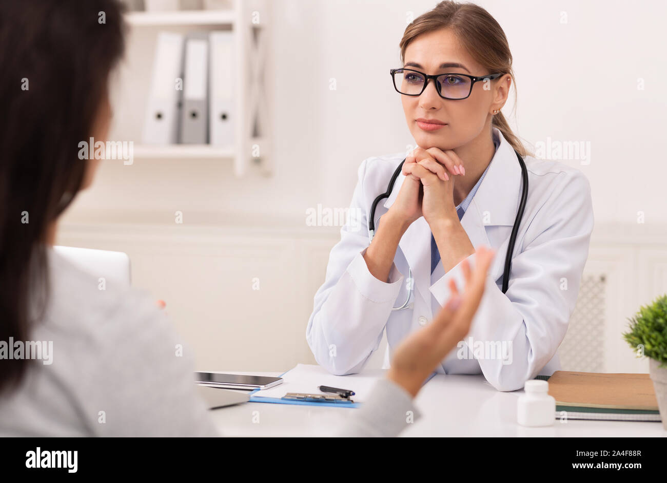 Doctor Woman Listening To Patient During Medical Appointment In Office Stock Photo