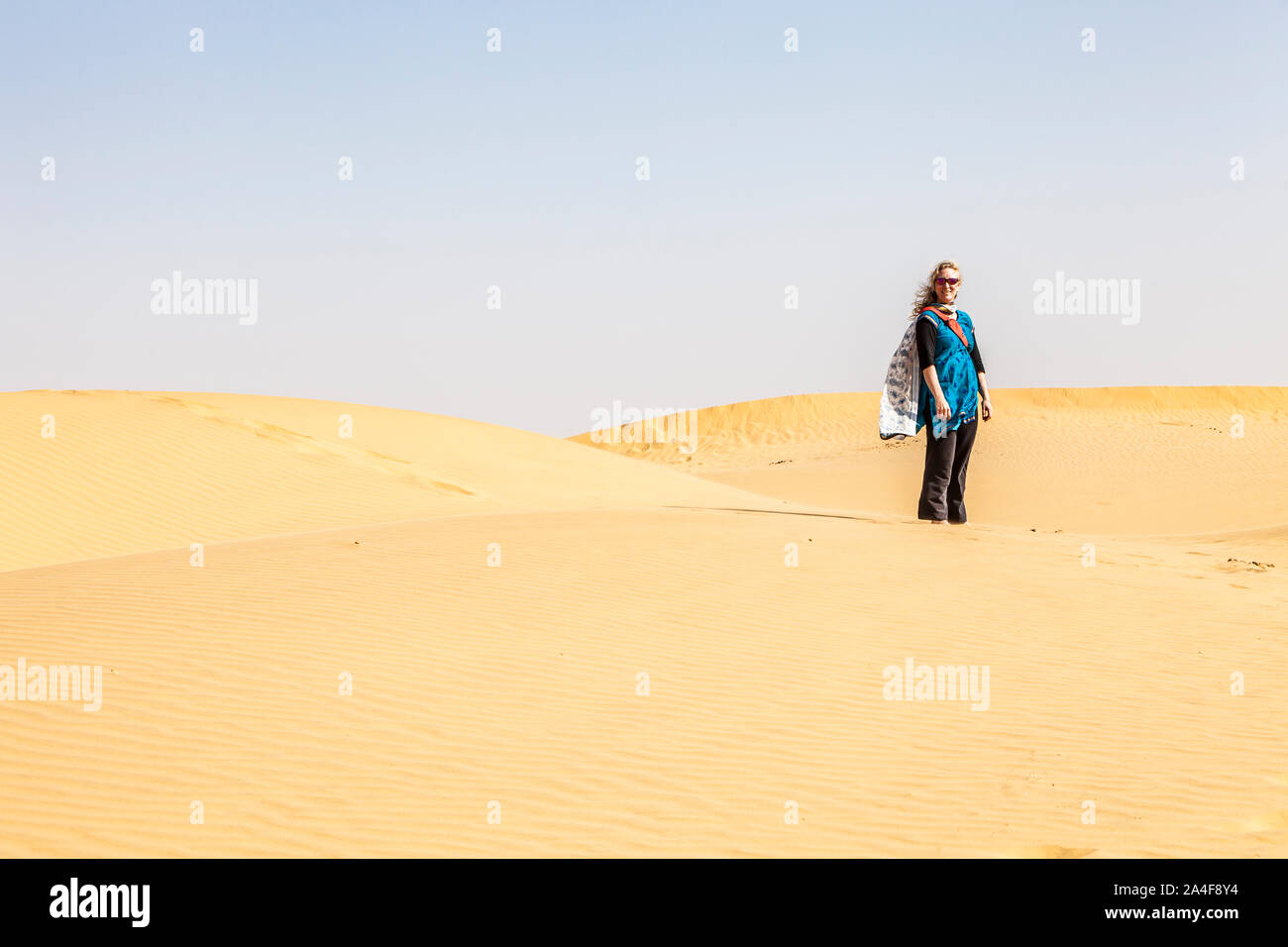 A woman standing for a picture on the sand dunes of the Thar Desert. Western Rajasthan, India. Stock Photo