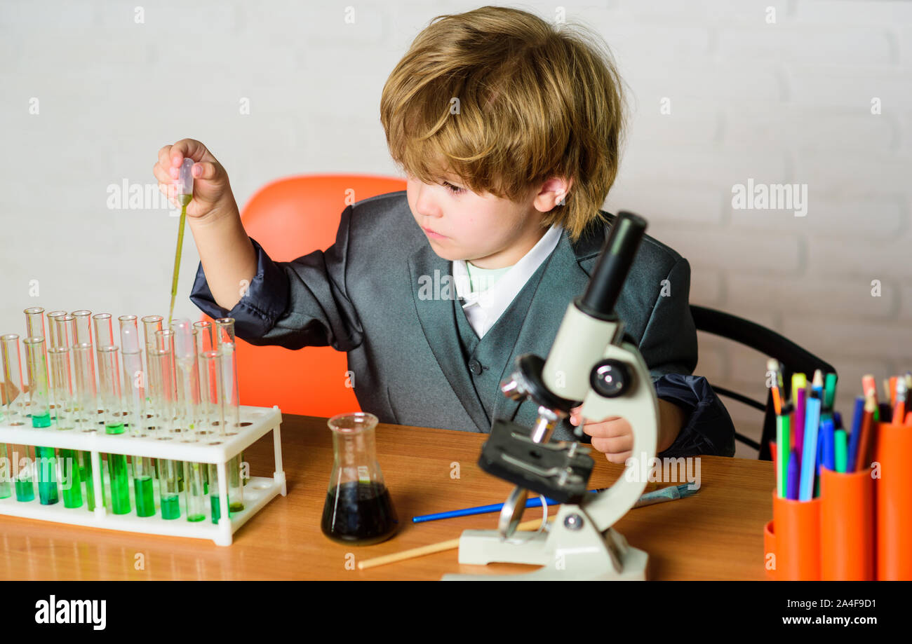 Little kid learning chemistry in school laboratory. kid scientist study