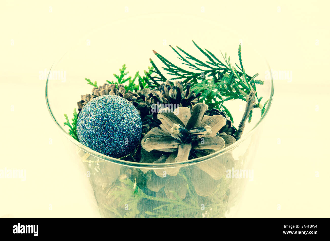 pine cone and blue bauble in glass vase christmas concept Stock Photo