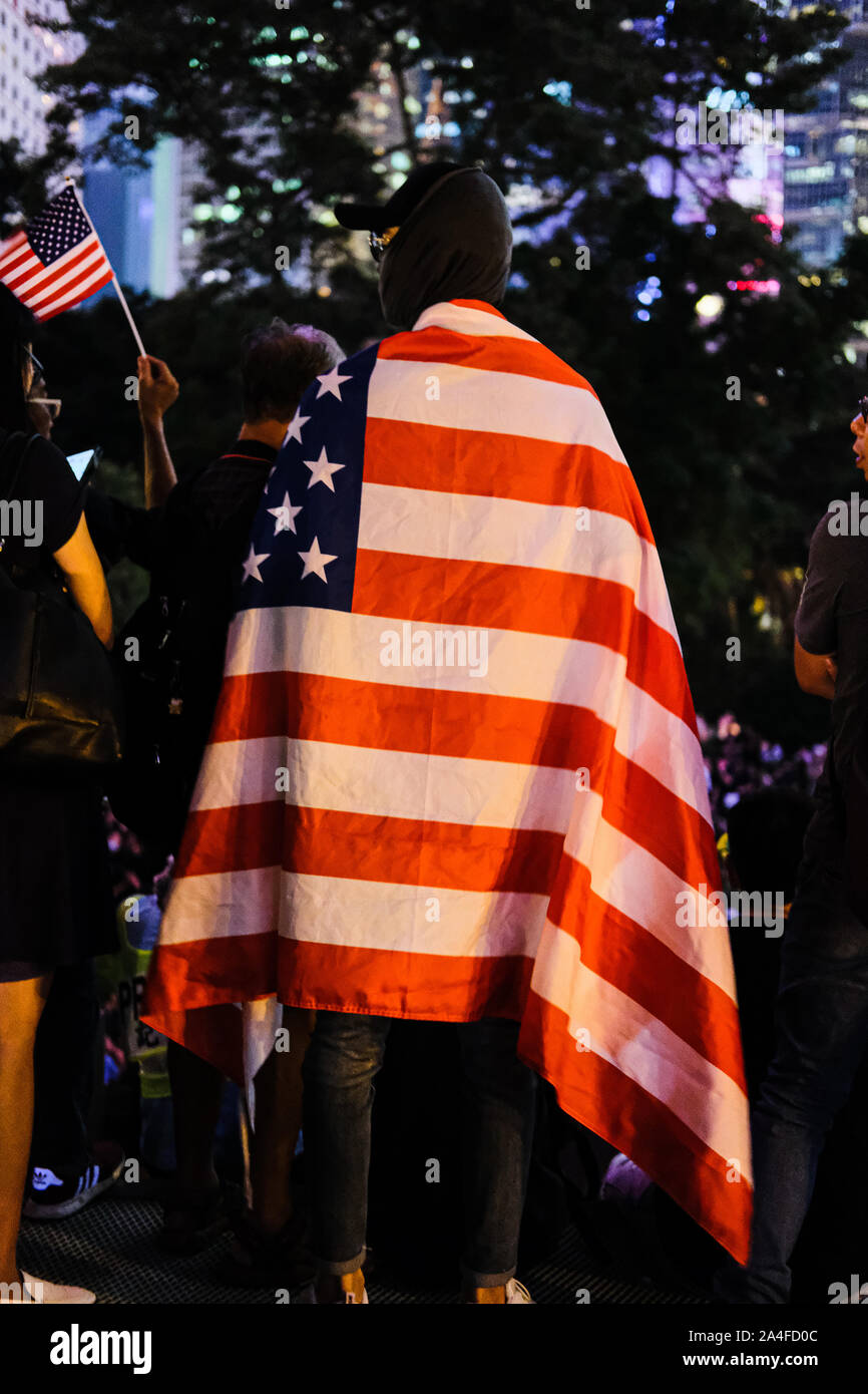 Hong Kong. 14th Oct, 2019. A protester wraps with flag of the United States attends Hong Kong Human Rights and Democracy Act Rally at Chater Garden in Central District Hong Kong. This rally was proposed to US lawmakers that they should pass the act that would help the Hong Kong democracy. ItÃs aimed at putting pressure on Beijing to uphold its promise to preserve Hong KongÃs autonomy. Credit: Keith Tsuji/ZUMA Wire/Alamy Live News Stock Photo
