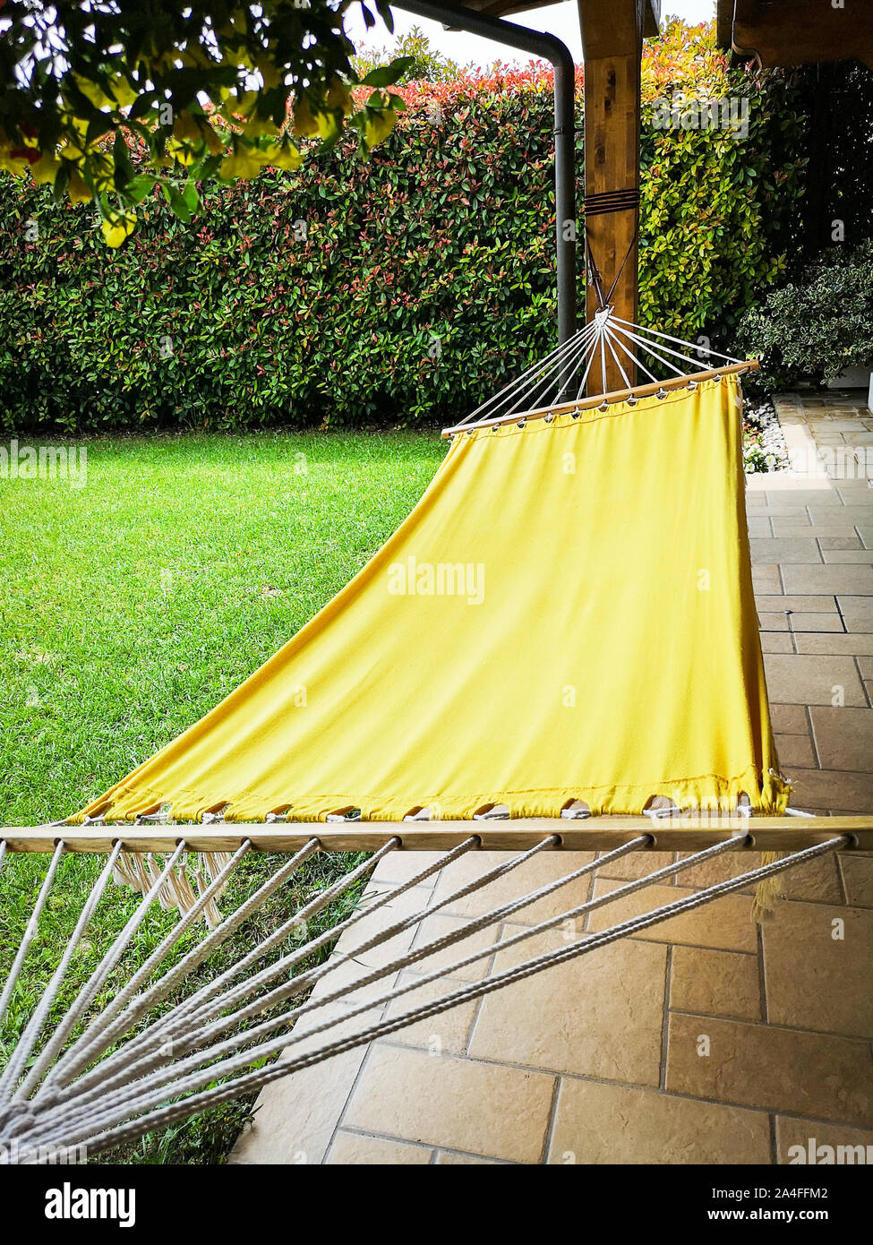 Yellow hammock in the garden of a country house. Stock Photo