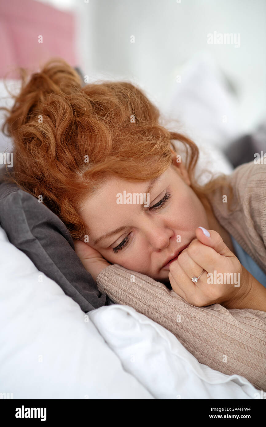 Curly sick woman wearing ring trying to fall asleep Stock Photo Alamy