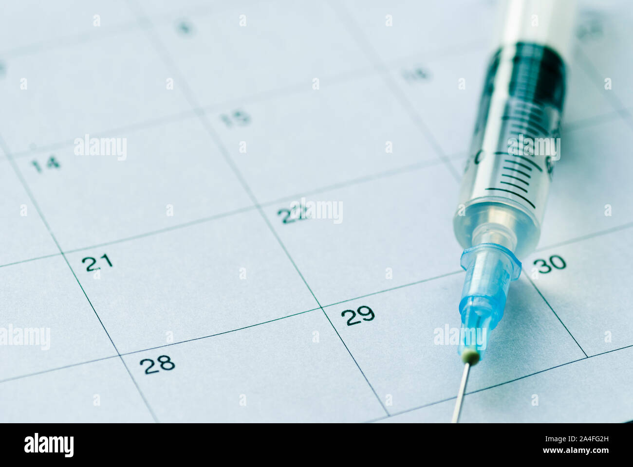 Medical syringe with transparent vaccine on white calendar background ...