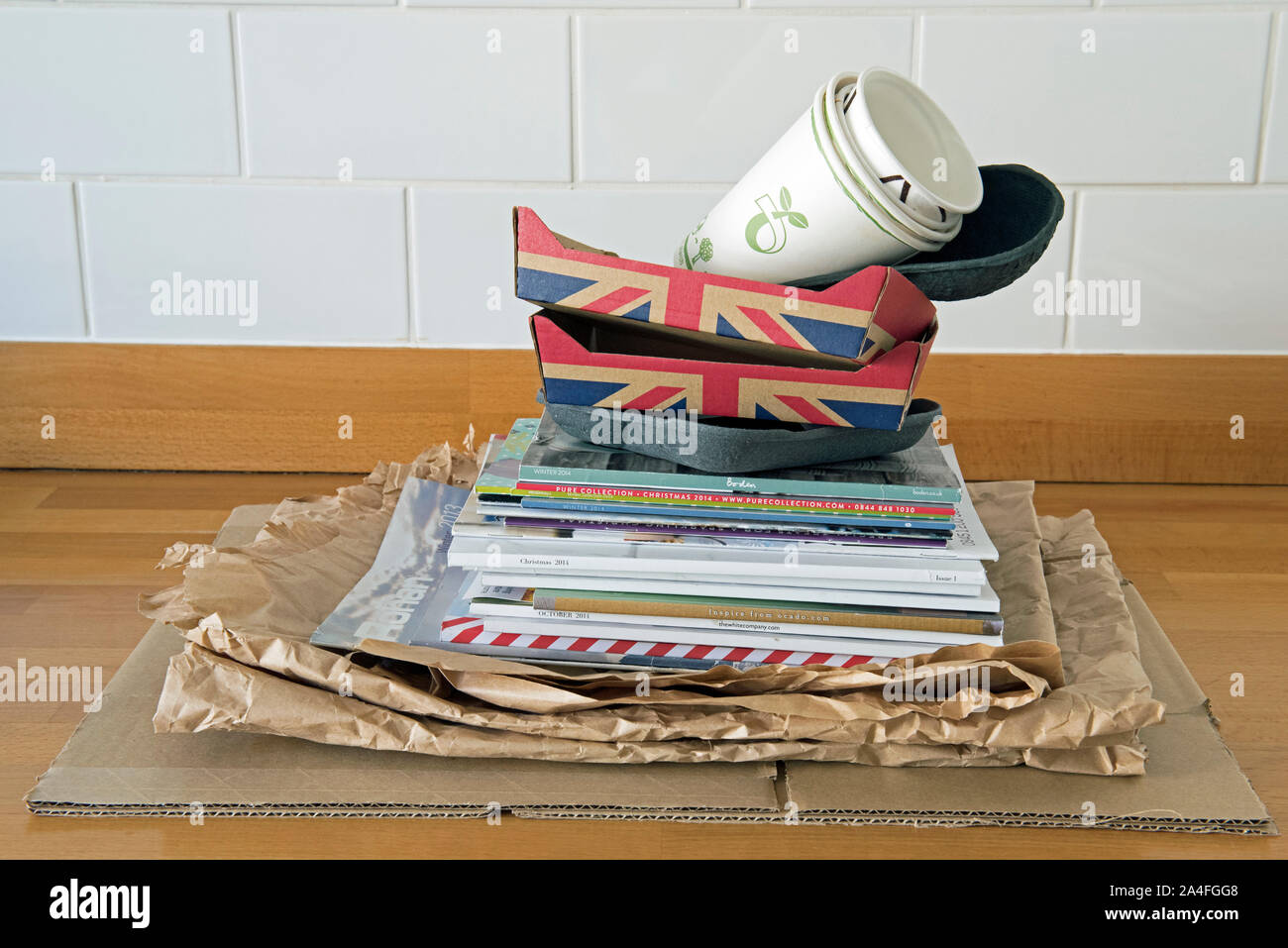 Recyclable household items on kitchen worktop ready for recycling including, paper, cardboard fruit holders and old catalogues.  Zero waste Stock Photo