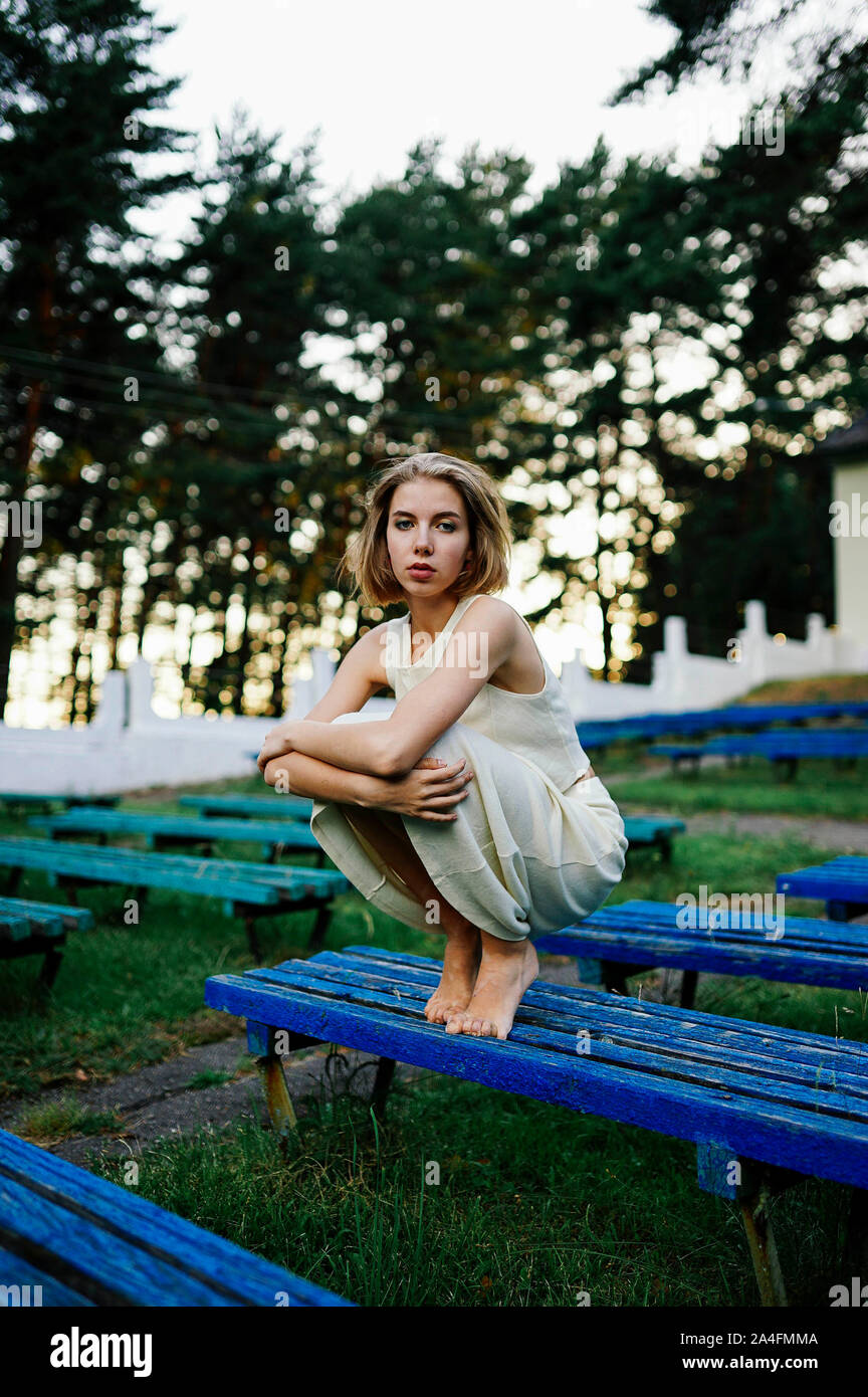 Woman blonde sitting on a bench in the park Stock Photo