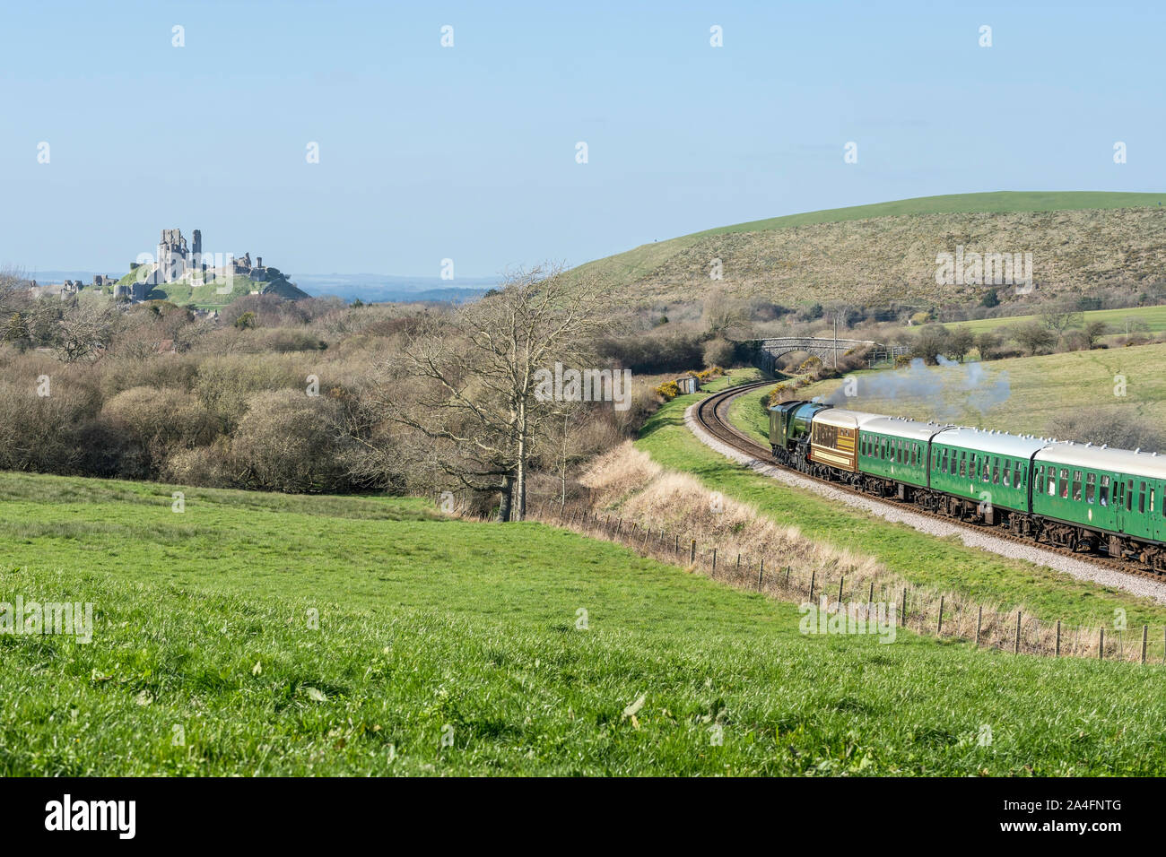 Railway and coach pass the Corfe Castle in Dorset, UK Stock Photo