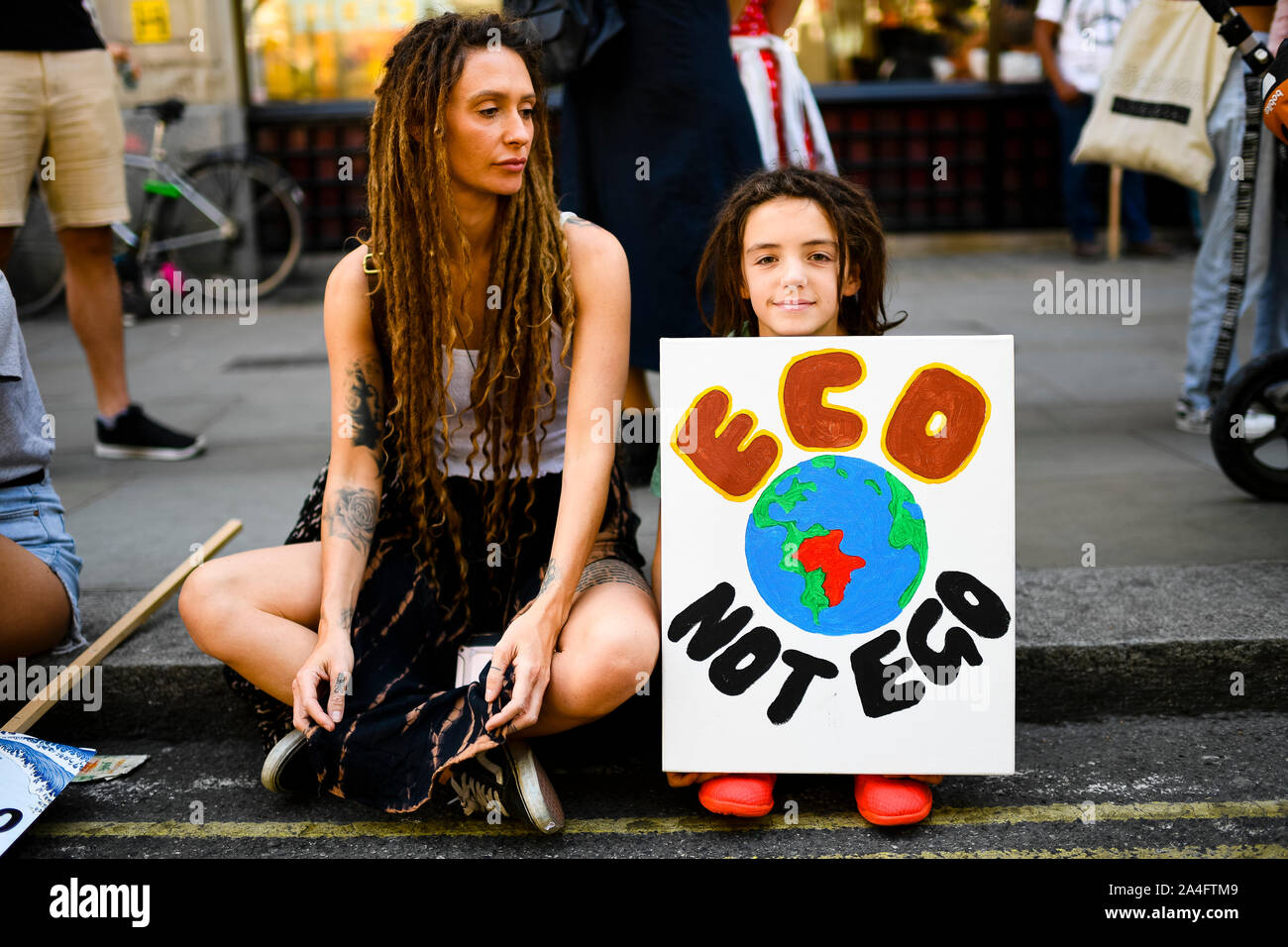 London, UK. Young protester with an 'Eco not ego' sign outside the Brazilian embassy during an Extinction Rebellion protest. Stock Photo