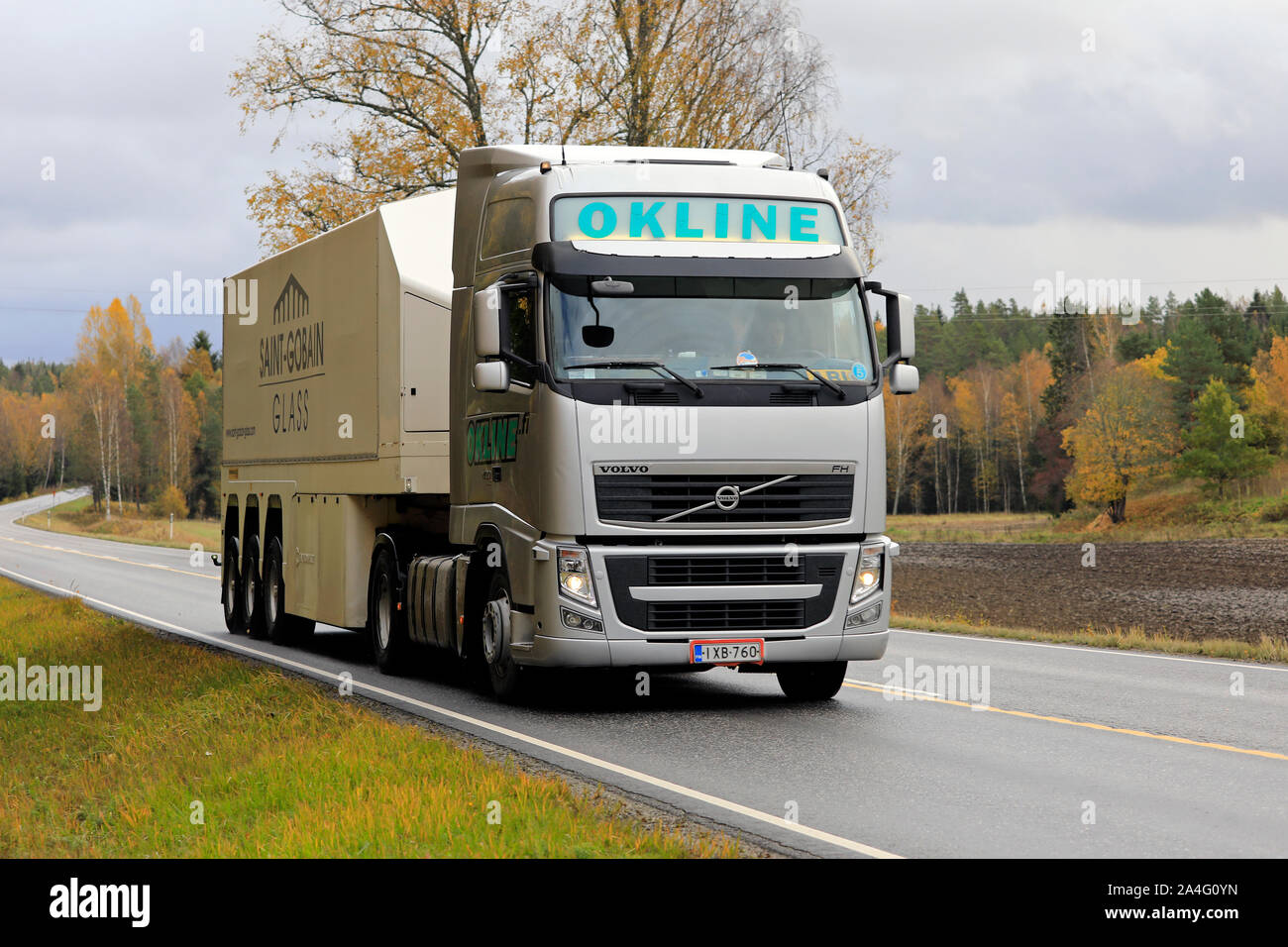 Silver Volvo FH truck of Okline Oy pulls Saint-Gobain glass trailer along rural highway on a day of autumn. Salo, Finland. October 11, 2019. Stock Photo
