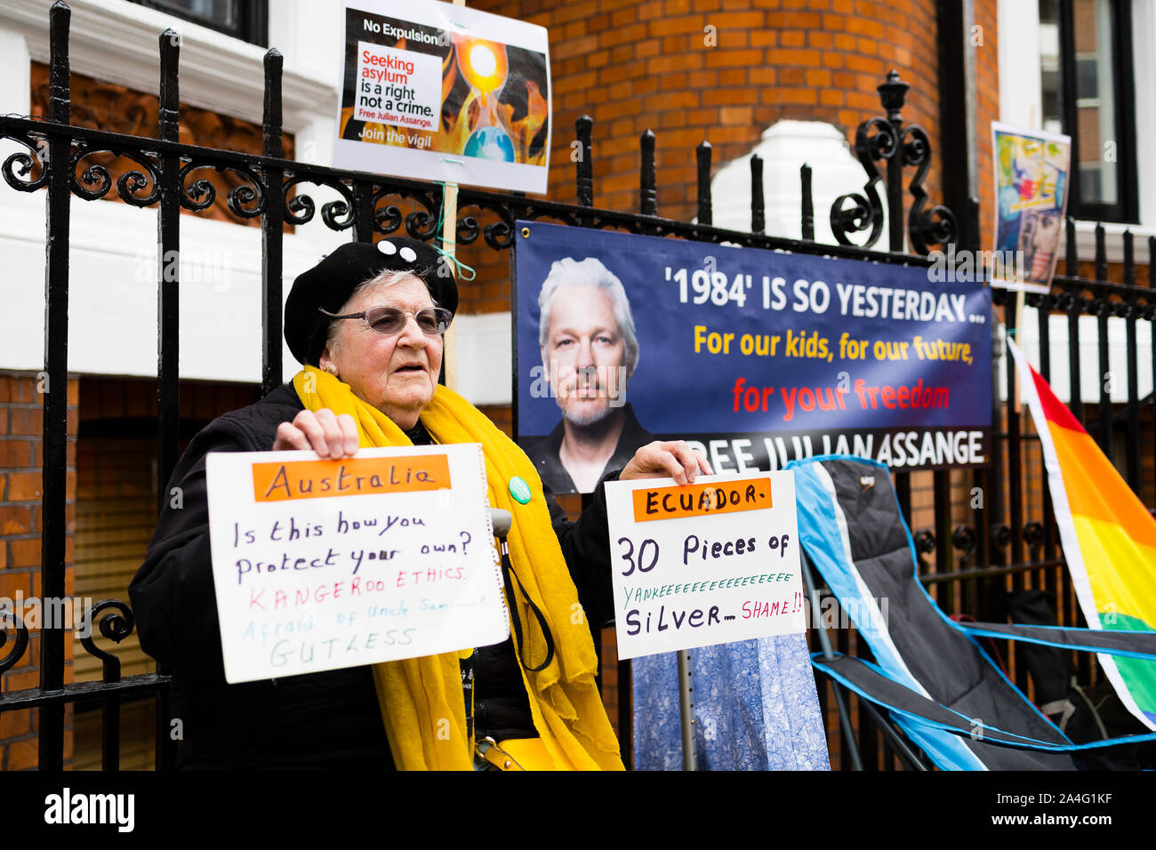 London, UK. A woman holds signs protesting the treatment of Julian Assange outside the Ecuadorian Embassy. Assange has been in the embassy since Augus Stock Photo