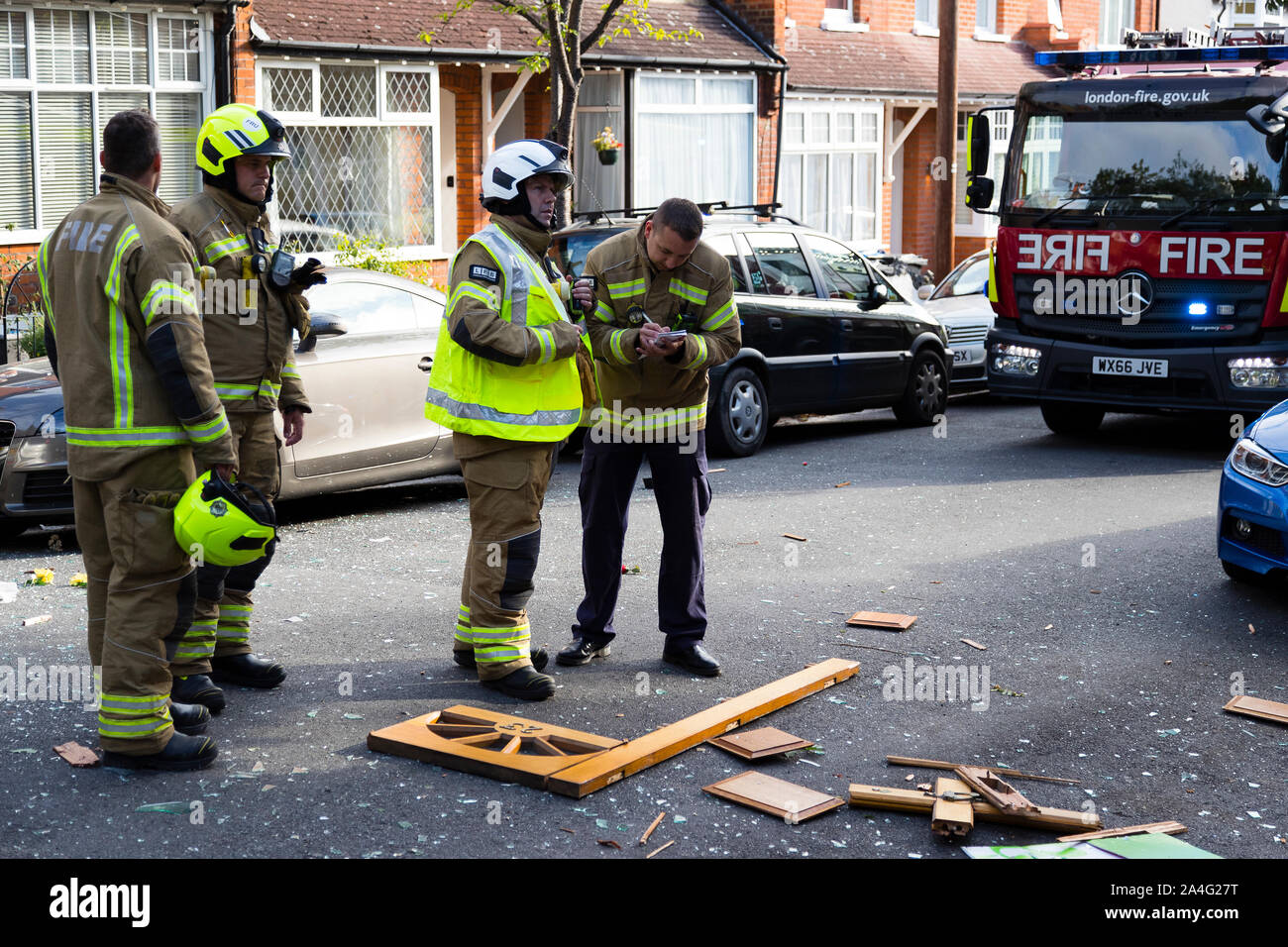 Shattered glass and a front door lie in the road on Foxley Gardens, a terraced street in Purley, after a large gas explosion. The house's resident, kn Stock Photo