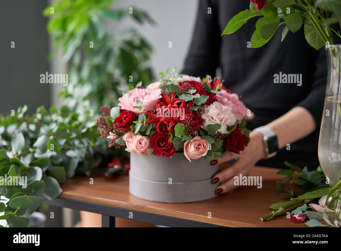 Floral shop concept . Florist woman creates flower arrangement in a round box. Beautiful bouquet of mixed flowers. Handsome fresh bunch. Flowers Stock Photo