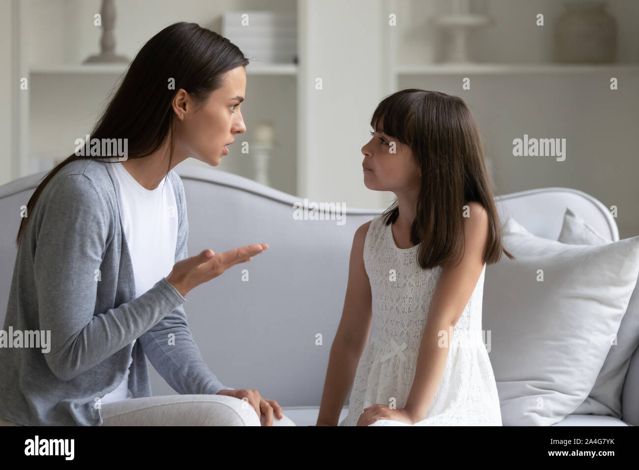 Irritated woman lecturing little stubborn daughter for bad behavior. Stock Photo