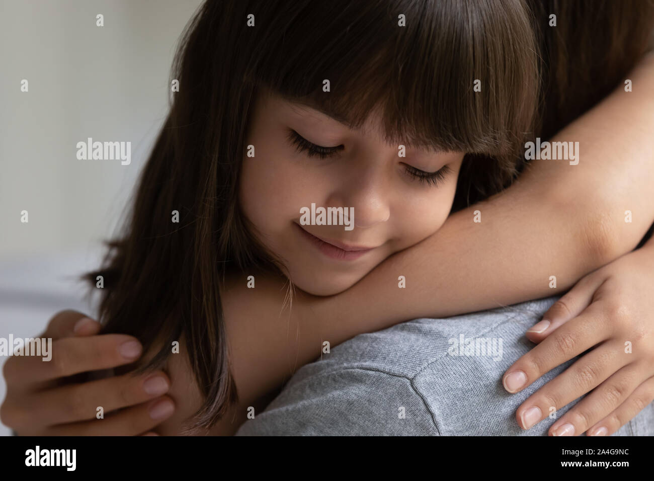 Smiling adorable little daughter enjoying tender family moment with mother. Stock Photo