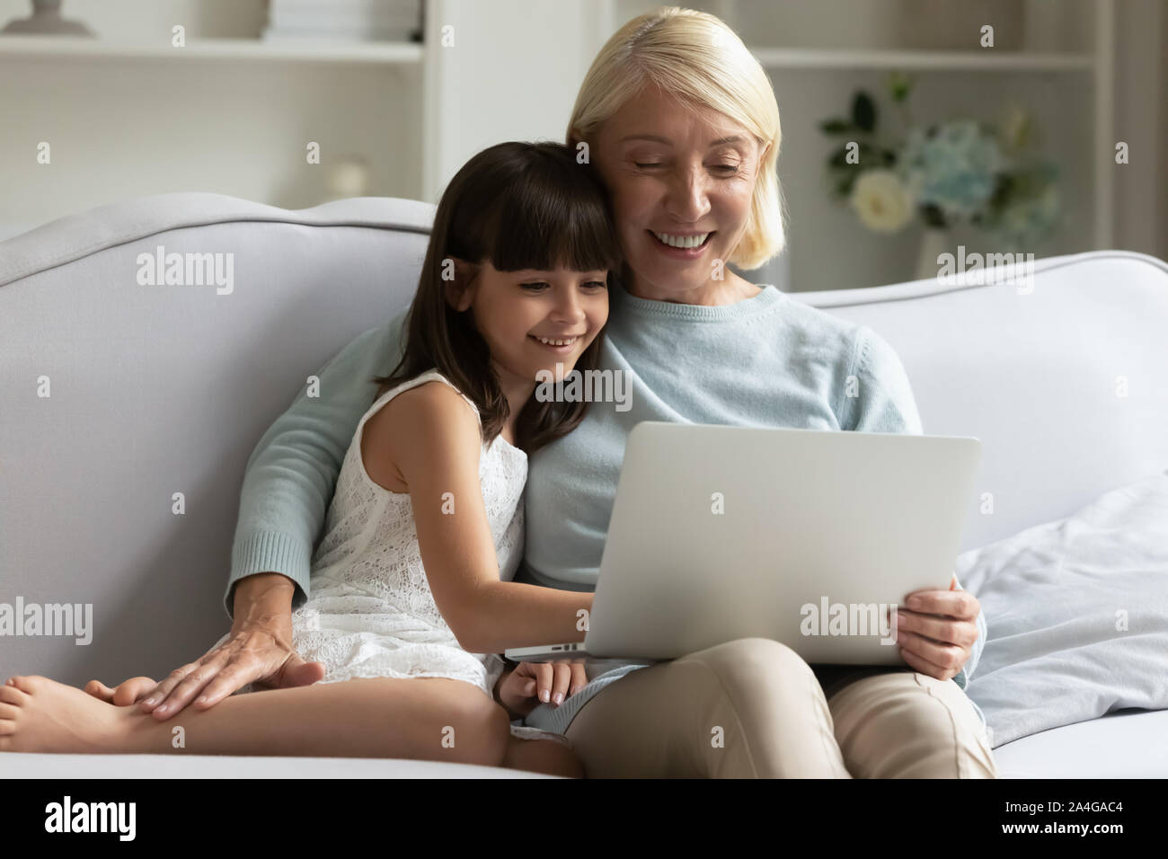 Small Girl With Granny Shopping Watching Funny Movie On Laptop Stock Photo Alamy