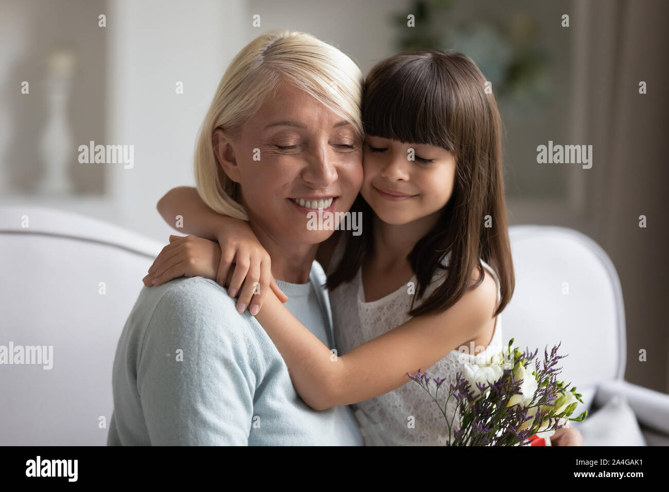 Happy mature grandmother bonding little adorable granddaughter. Stock Photo
