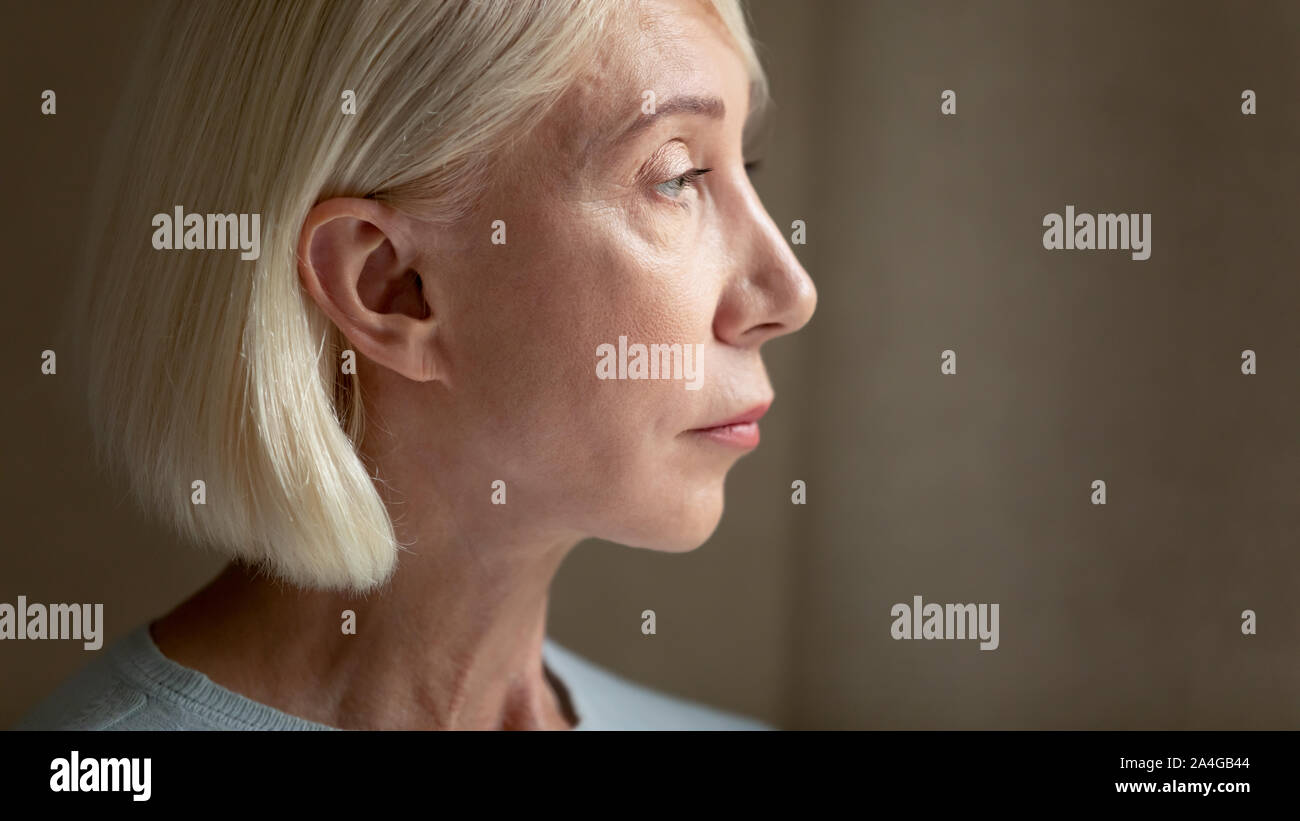 Lost in thoughts upset mature woman feeling lonely. Stock Photo