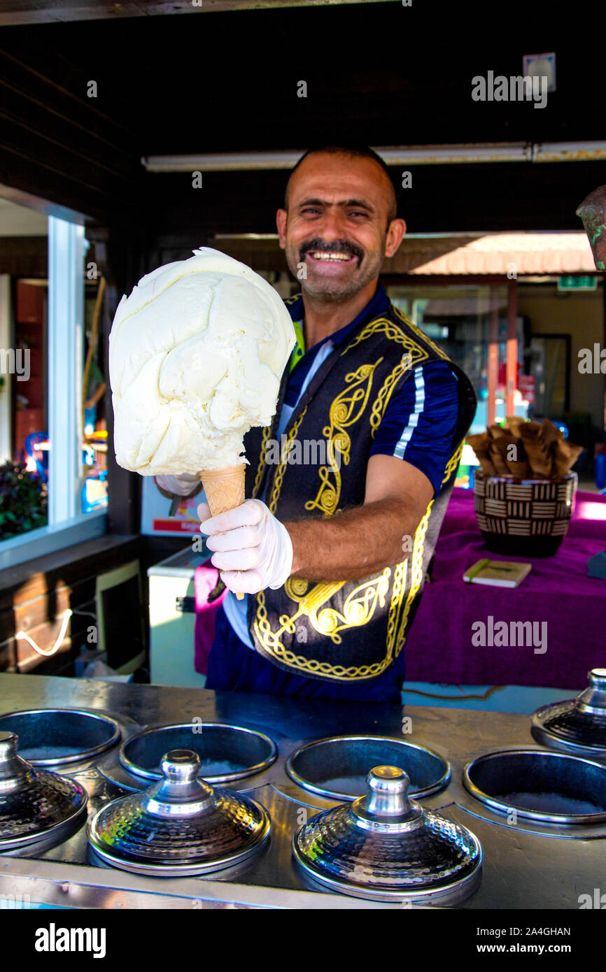 Street ice cream vendor in traditional Ottoman clothing serving Turkish goat's milk mastic ice cream in Fethiye, Turkish Riviera, Turkey Stock Photo