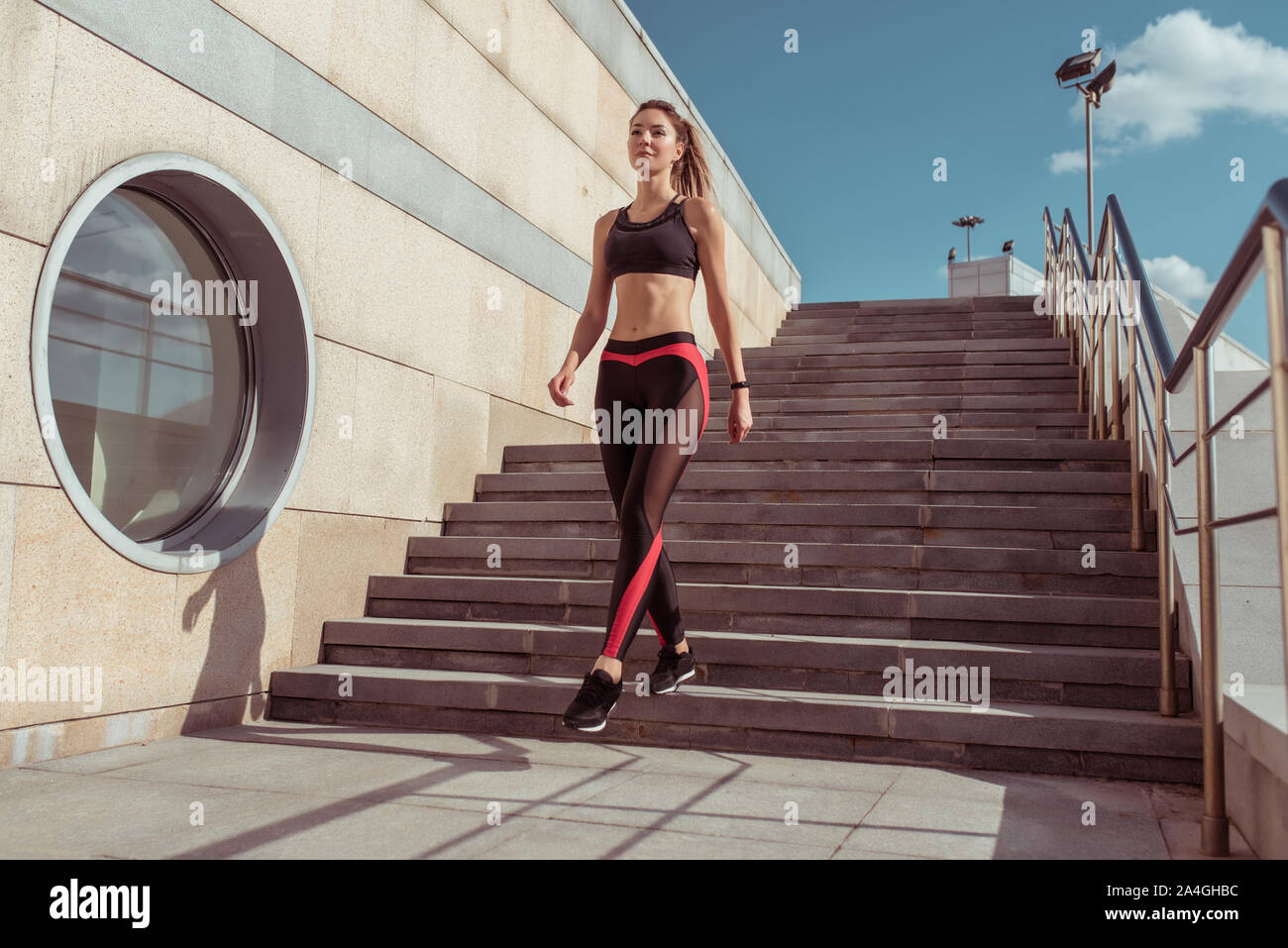 Sports girl goes in summer city. Sportswear Leggings Top. Step background. Motivation  for fitness workout lifestyle. Free space text. Tanned and slim Stock Photo  - Alamy