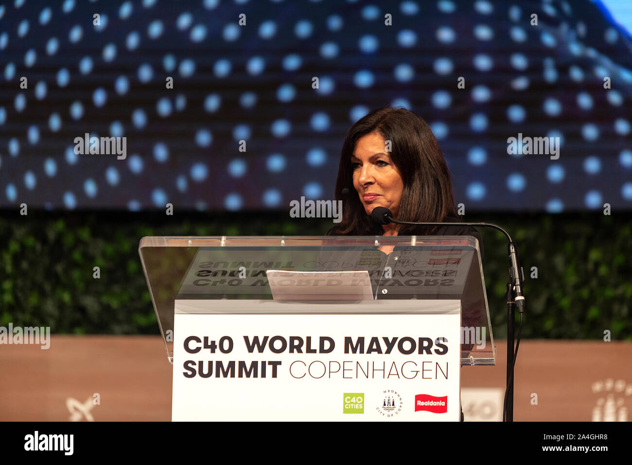 COPENHAGEN, DENMARK -  OCTOBER 10, 2019: Anne Hidalgo, Mayor of Paris and Chair of the C40, during her hand-over speech of the Chair to Eric Garcetti, Mayor of Los Angeles, at the C40 World Mayors Summit 2019 in Copenhagen. More than 70 mayors of some of the world’s largest and most influential cities representing some 700 million people meet in Copenhagen from October 9-12 for the C40 World Mayors Summit. The purpose with the summit in Copenhagen is to build a global coalition of leading cities, businesses and citizens that rallies around radical and ambitious climate action. Also youth leade Stock Photo