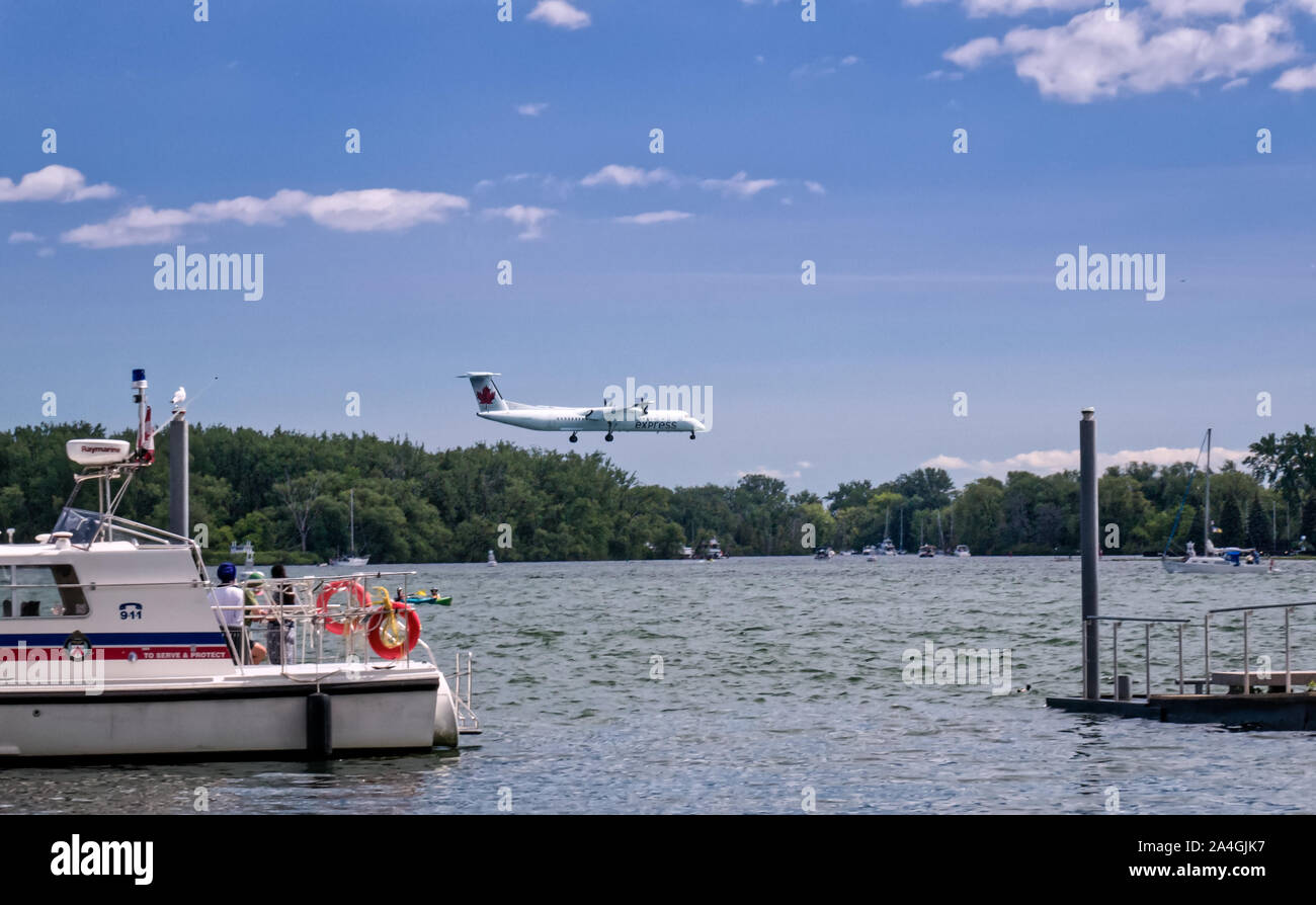 Toronto, Ontario, Canada - 2019 06 30: Air Canada turboprop aircraft descending to Billy Bishop Toronto City Airport above the waters of the Toronto Stock Photo