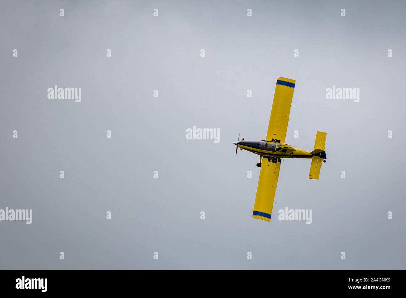Sheffield, Canterbury, New Zealand, October 14 2019: A yellow crop duster, or top dressing plane, spreads fertiliser over crops in a farm field Stock Photo