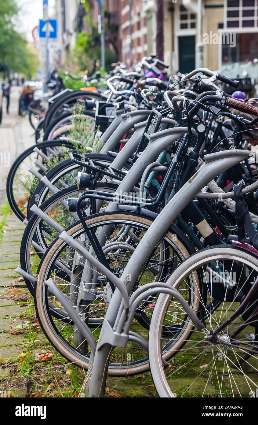 Street bicycle parking point with multiple simple bikes parked Stock Photo