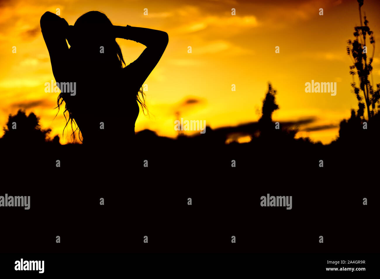 Photo in low angle shot of a silhouette of a woman at sunset Stock Photo
