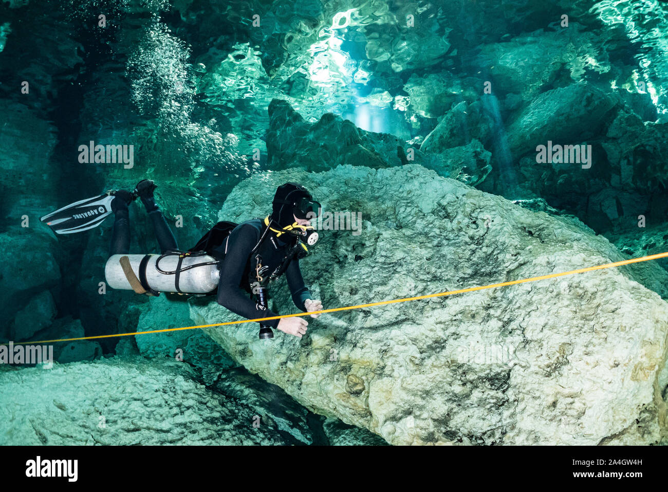 A scuba diver explores the cave passages of Mexico's famed Dos Ojos cenote. Stock Photo