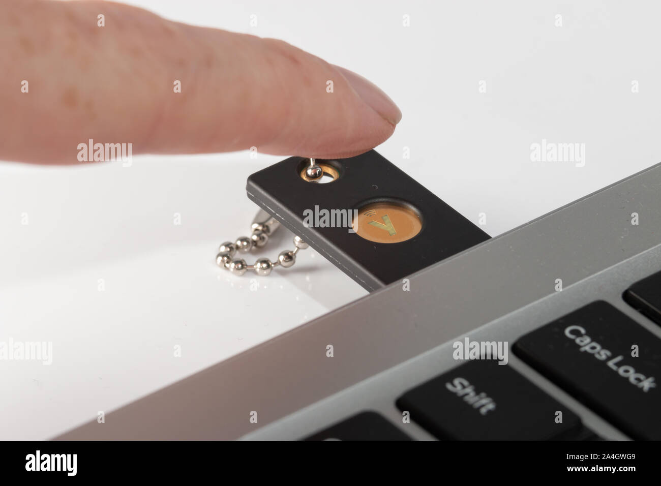 A Yubikey 5 hardware security key being used on a laptop computer Stock Photo