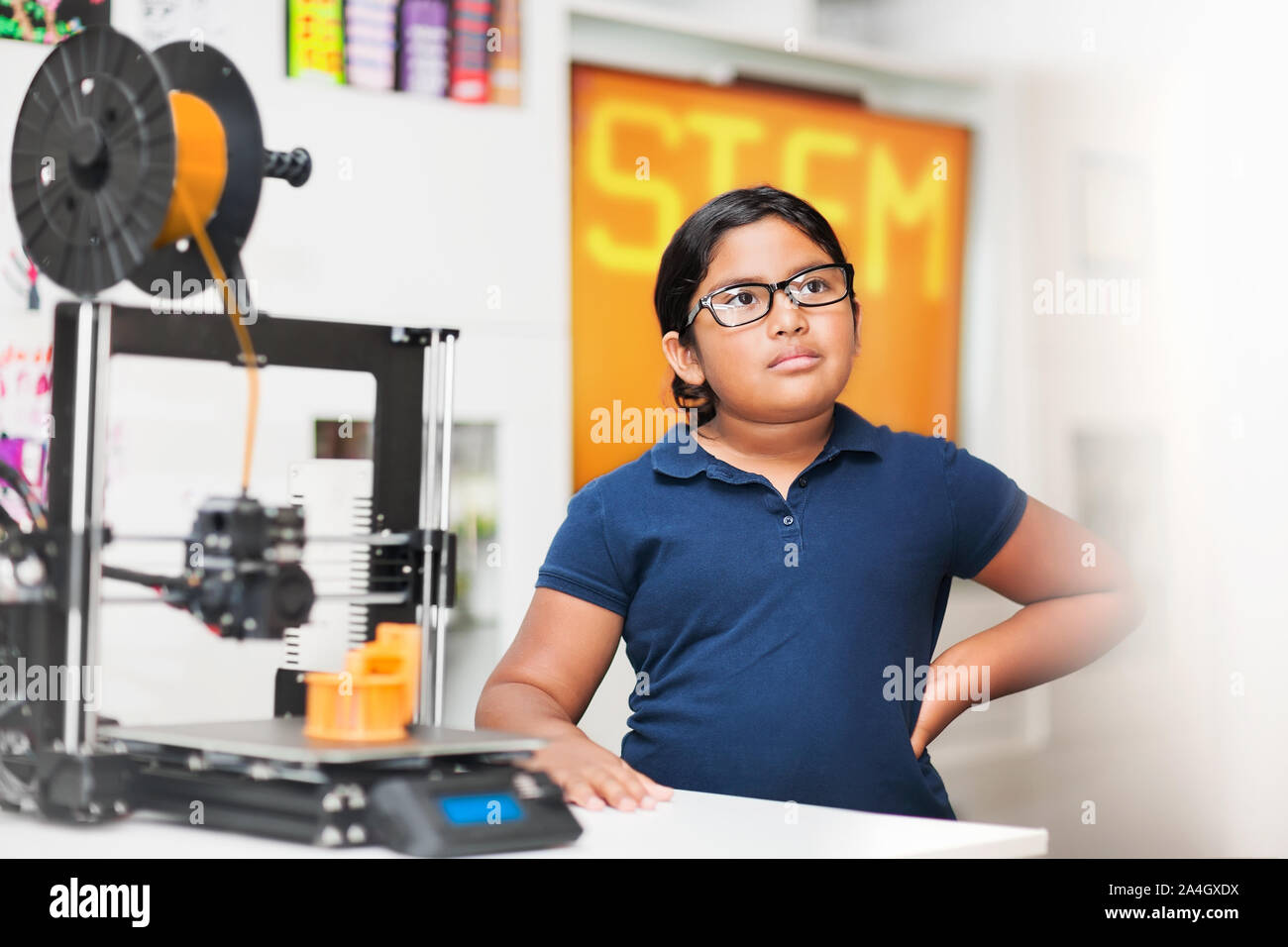 Young girl wearing glasses in a stem class who is representing minority students learning 3D printing skills. Stock Photo