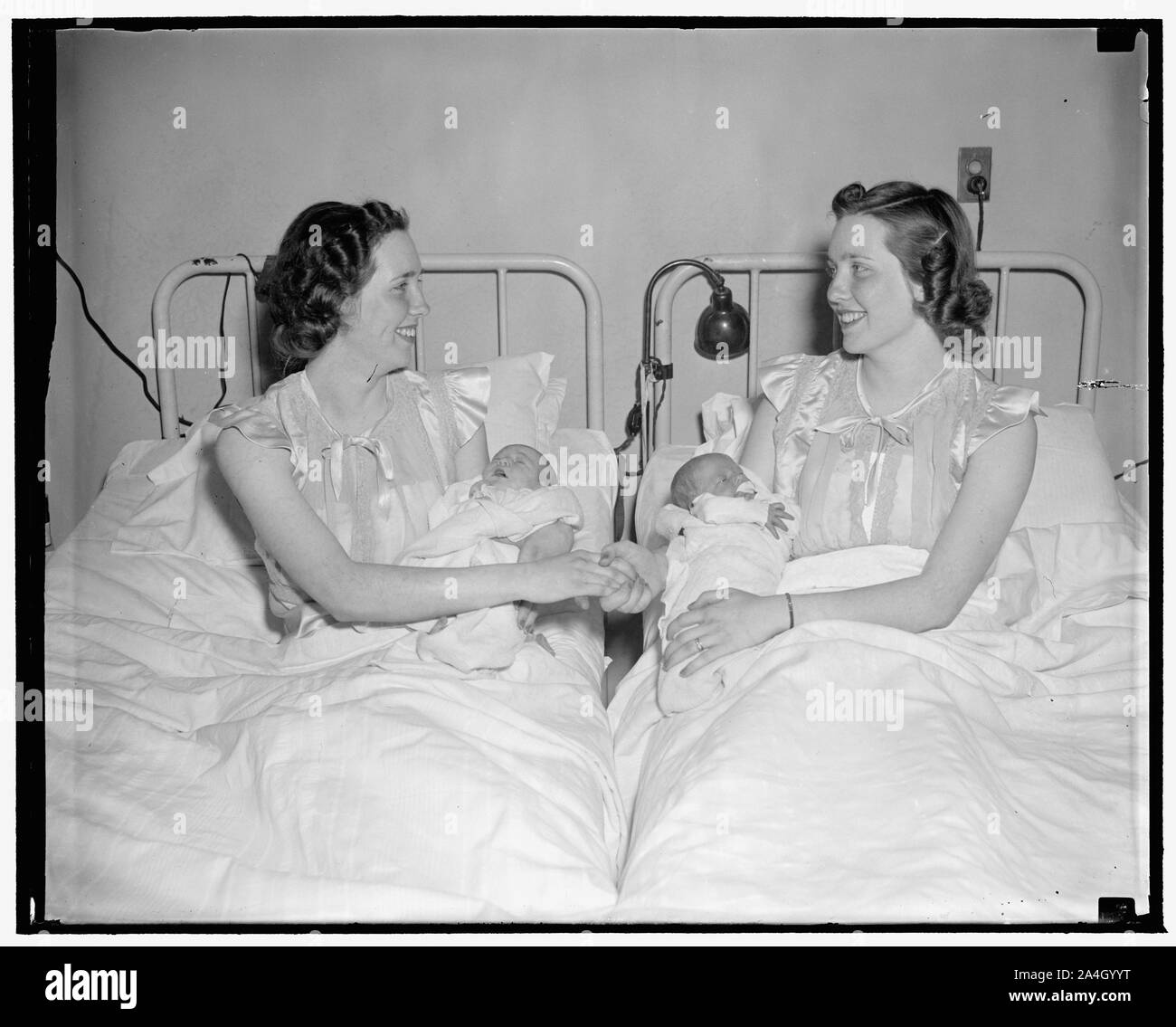 Twins become mothers together for second time in less than two years. Washington, D.C., April 7. Accustomed to doing practically the same things all their lives, these Washington twins, now mothers, have apparently decided that having their children together would certainly be in order. The mothers, Mrs. Eileen Moon, left, and Mrs. Kathleen Robie, last week gave birth to daughters to set a new record at Columbia Maternity Hospital. Mrs. Moon's youngster, whom she named Carol, was born on March 29, while Mrs. Robie's new daughter Nancy Lee first saw the light of day on April 1. This same thing Stock Photo