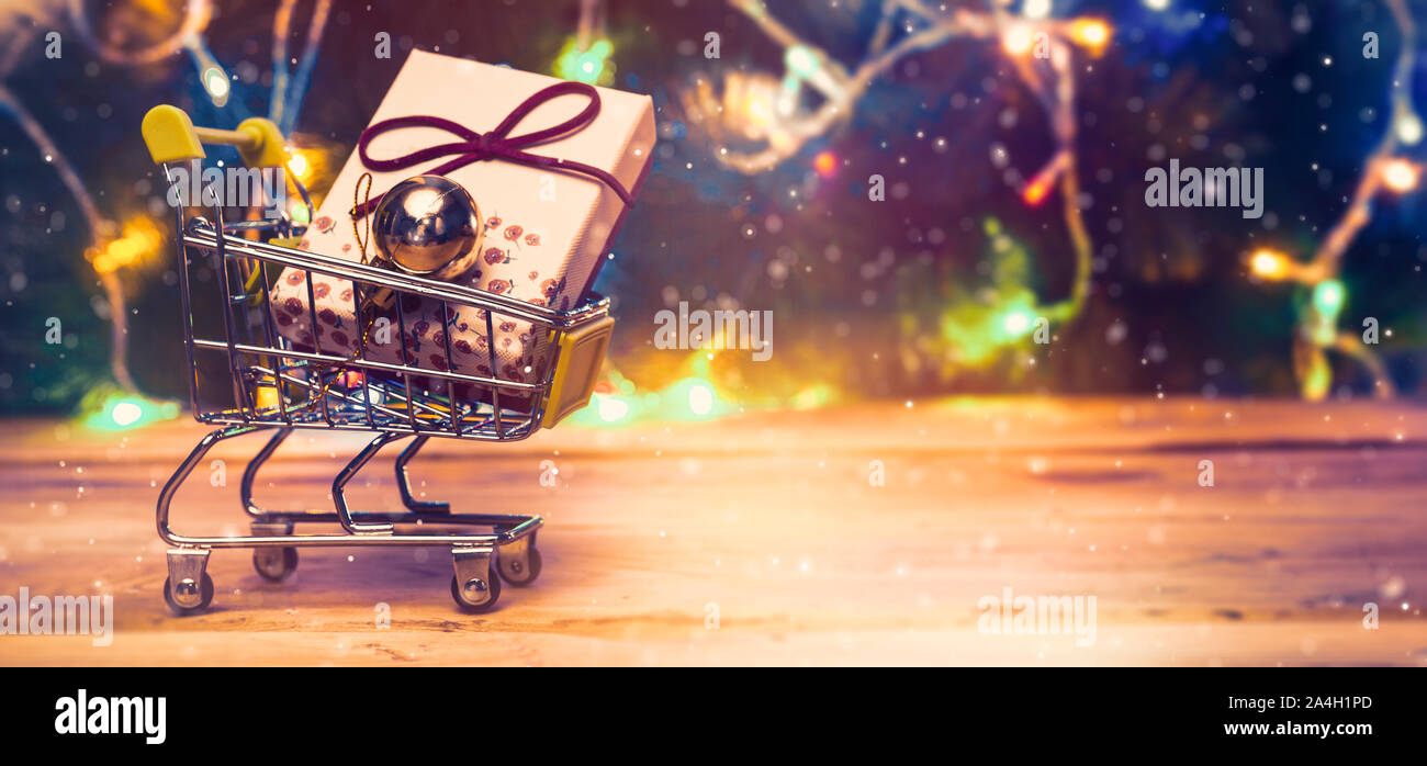 Shopping cart full of presents. Christmas gifts shopping. Online shopping, Black Friday and Ciber Monday concepts. Trolley cart with gifts. Copy space Stock Photo