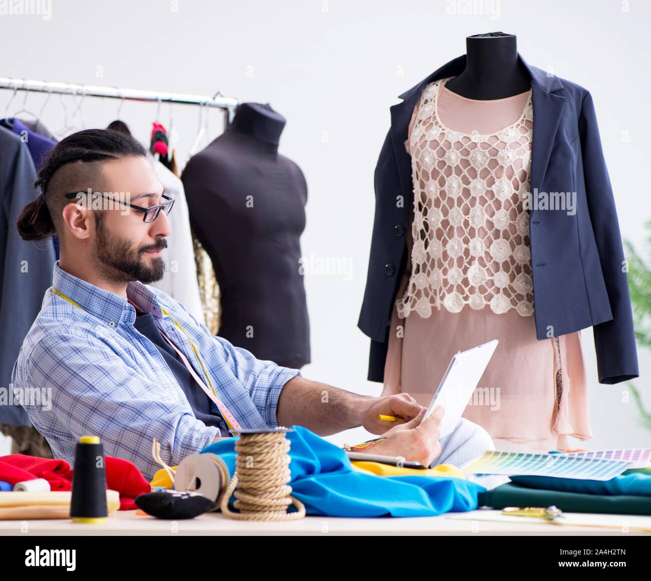 The male tailor working in the workshop on new designs Stock Photo - Alamy