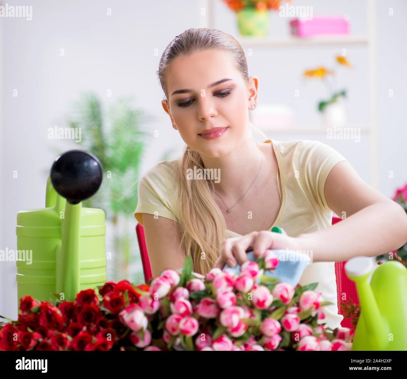 The young woman watering plants in her garden Stock Photo - Alamy