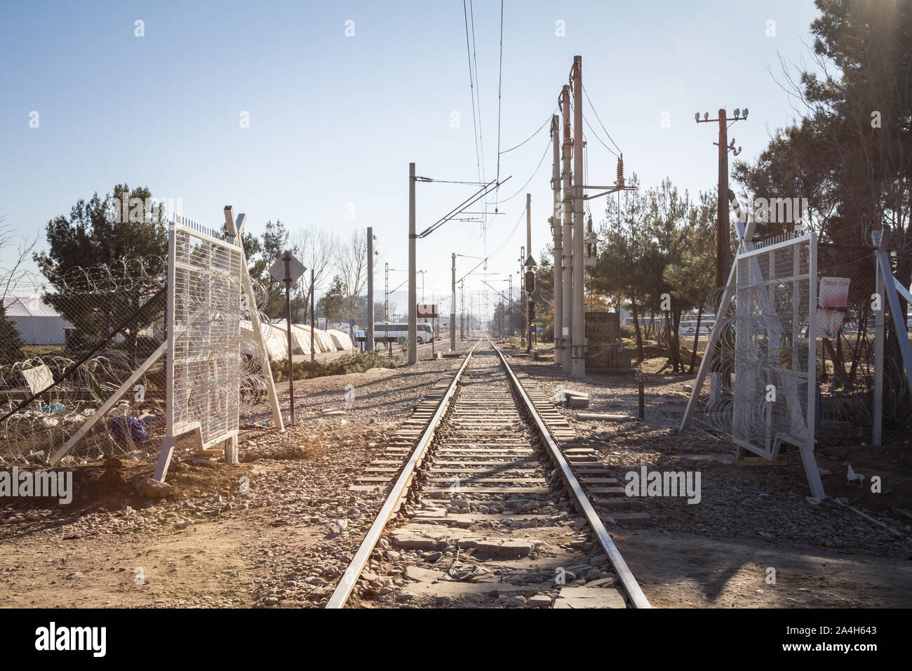 GEVGELIJA, MACEDONIA - DECEMBER 23, 2015: Railway line crossing the border fence wall at the Macedonia Greece border built during the refugee crisis o Stock Photo