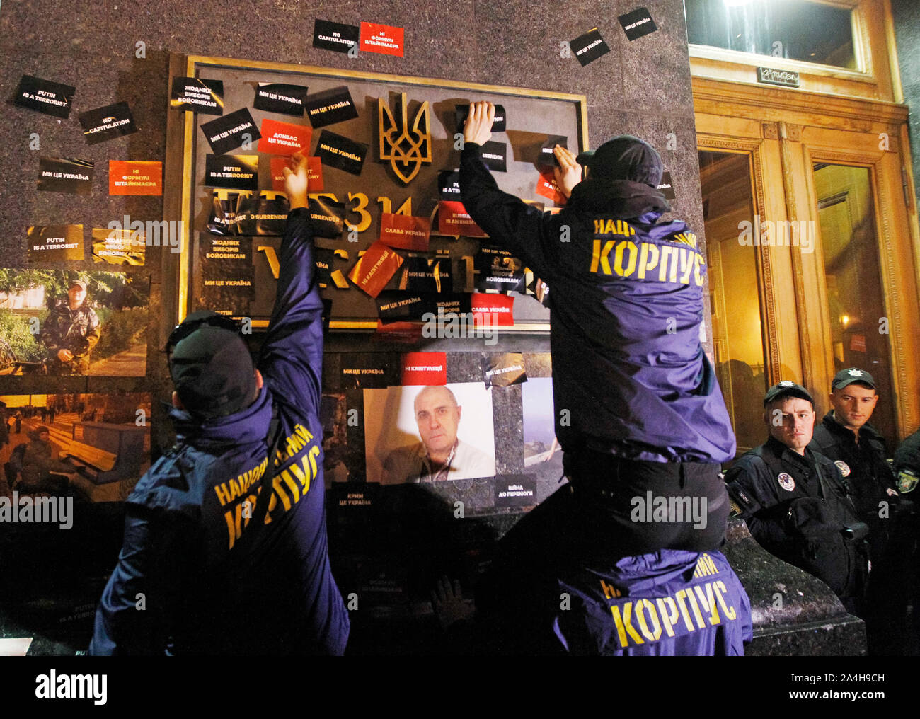 Kiev, Ukraine. 14th Oct, 2019. Ukrainian far-right activists places stickers at the Presidential Office as they protest against the so-called Steinmeier Formula during the march commemorating the 77th anniversary of the founding of the UPA.The Ukrainian Insurgent Army (UPA) active fought for Ukrainian independence from 1942 to 1949, mostly in Western Ukraine against the German Nazi and Soviet regimes. Ukrainians also mark the Defender of Ukraine Day on the same date. Credit: SOPA Images Limited/Alamy Live News Stock Photo