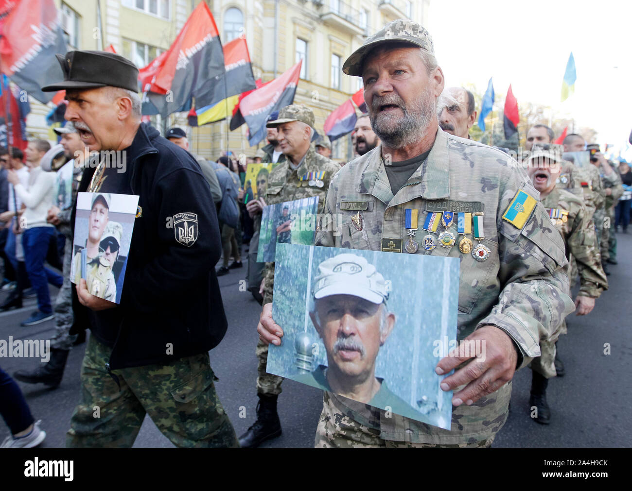 Kiev, Ukraine. 14th Oct, 2019. Ukrainian veterans who participated at the war conflict with pro-Russian separatist with photos of dead Ukrainian servicemen during the march commemorating the 77th anniversary of the founding of the UPA.The Ukrainian Insurgent Army (UPA) active fought for Ukrainian independence from 1942 to 1949, mostly in Western Ukraine against the German Nazi and Soviet regimes. Ukrainians also mark the Defender of Ukraine Day on the same date. Credit: SOPA Images Limited/Alamy Live News Stock Photo