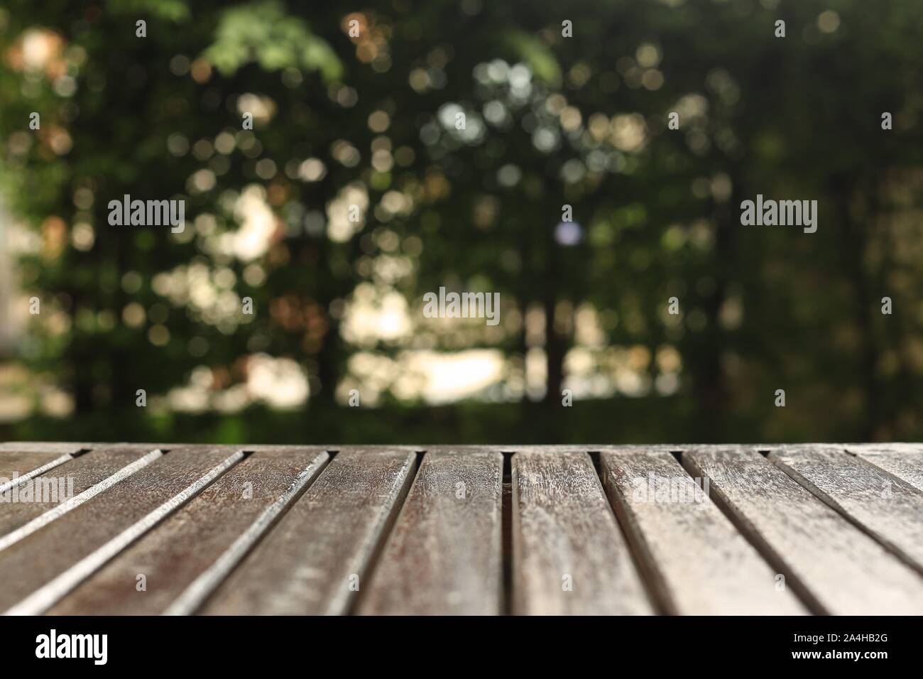 wooden floor background for products placement copy space. wood table in a garden. forest bokeh light background. warm tone image Stock Photo