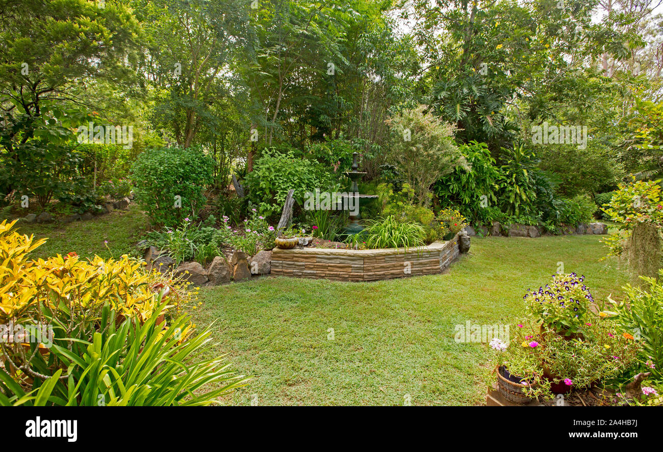 Immaculate and colourful garden with lawn and garden beds with water