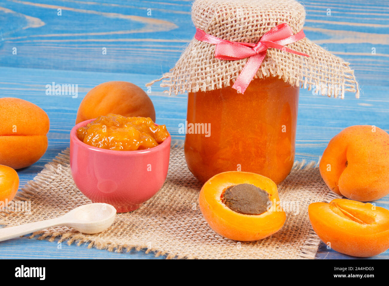 Apricot jam or marmalade in glass jar and ripe fruits on boards, concept of healthy sweet dessert Stock Photo