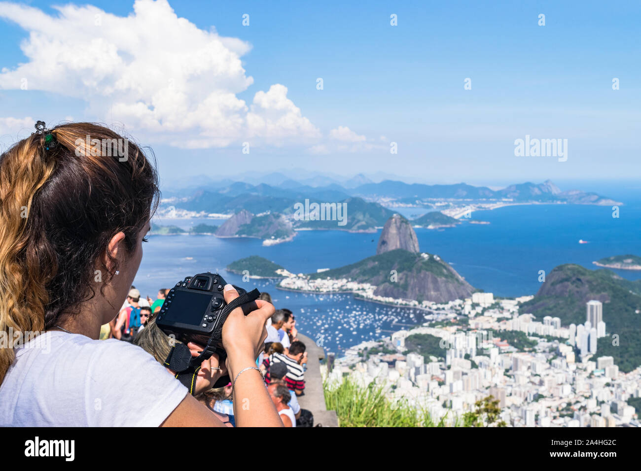 A woman with a camera taking picture of the landscape from Corcovado Mountain in Brazil Stock Photo